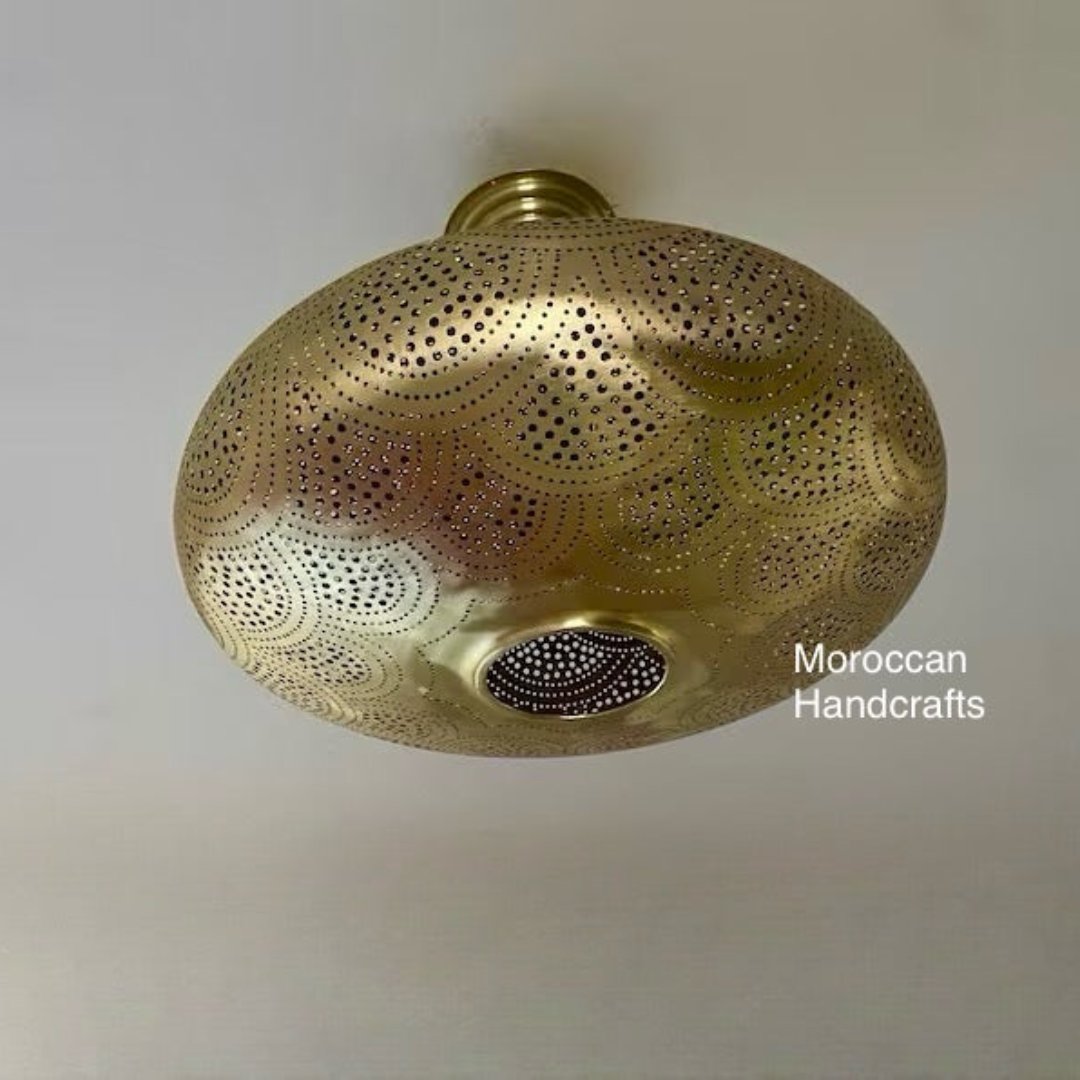Gold brass Moroccan pendant light hanging in a luxury room with warm ambient lighting.