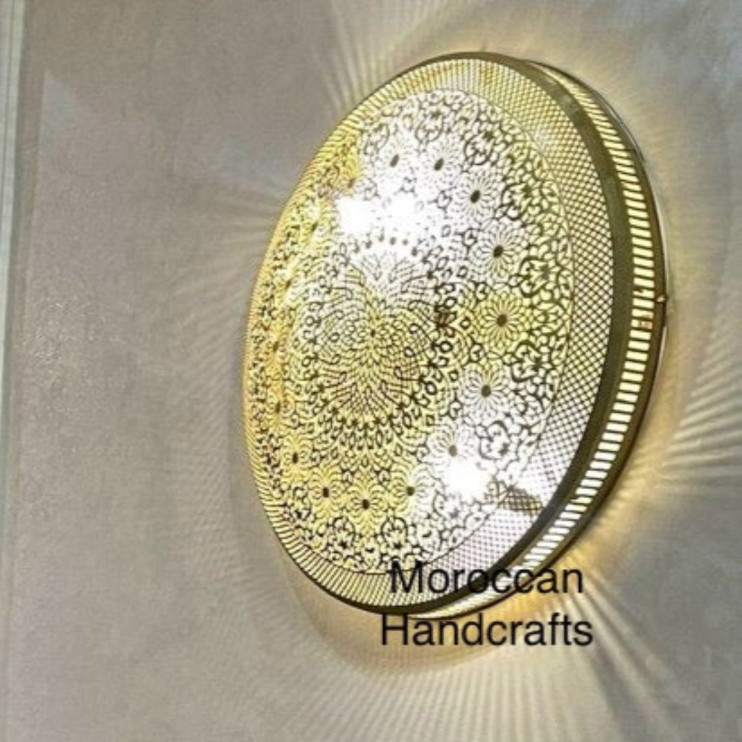 Handmade Square Moroccan brass wall sconce creating a soft light halo and featuring intricate geometric cut-outs.