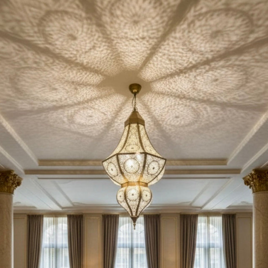 Close-up of a Moroccan brass ceiling light showing artisanal hand-punched details and warm light glow.
