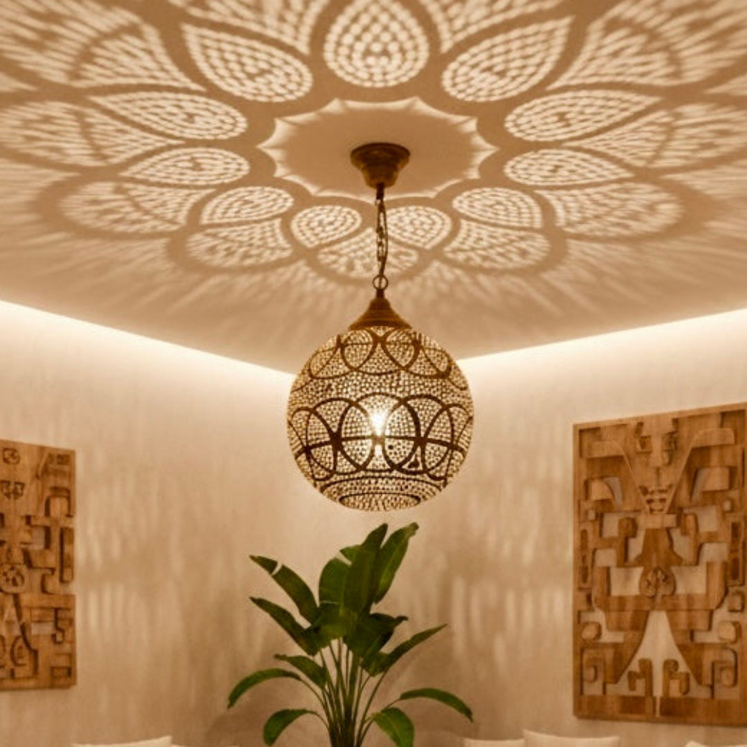 Spacious living room with a bohemian modern style, showcasing a large, handcrafted Moroccan brass sphere pendant lamp with beautiful shadow projections.