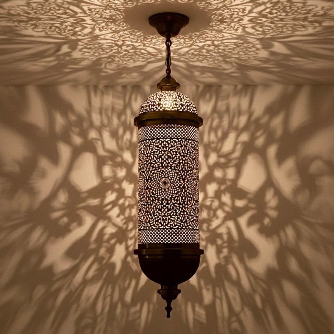 Handcrafted Moroccan brass lantern with intricate filigree pattern casting beautiful shadow art on ceiling and walls.