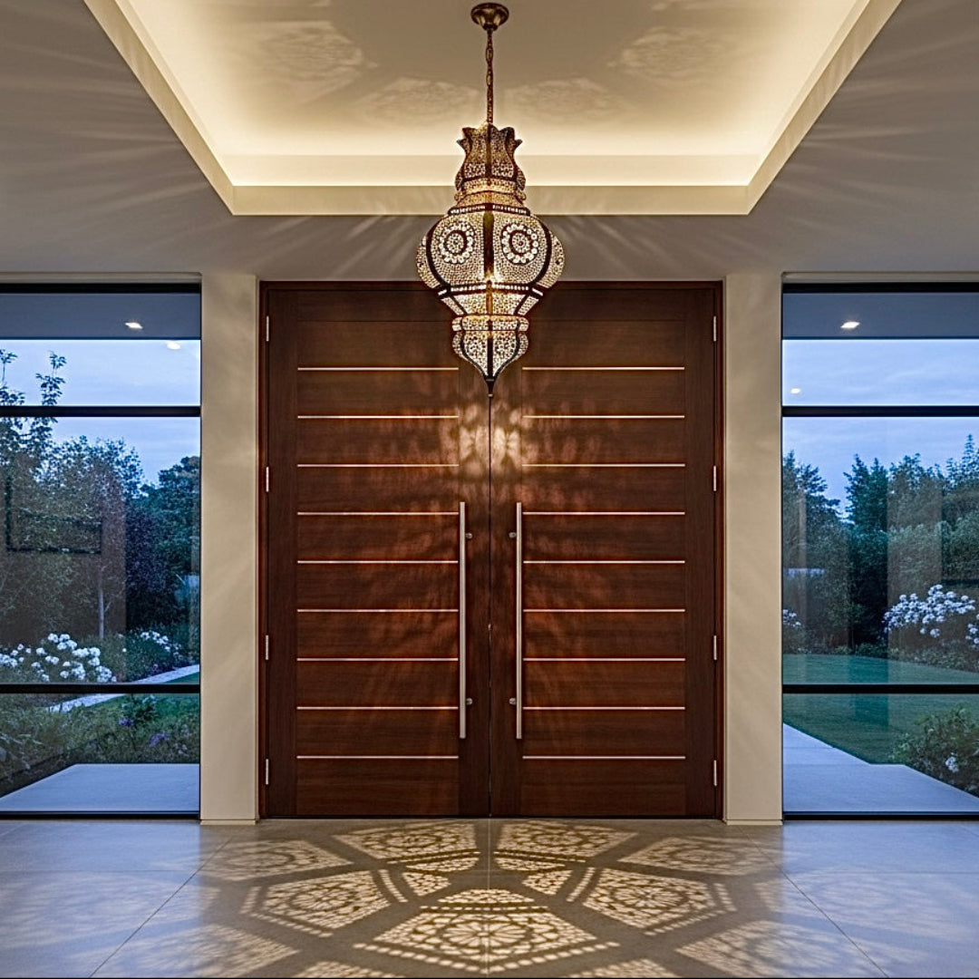 Exquisite handcrafted Moroccan brass lantern in a modern minimalist entryway, creating artistic light reflections on the floor and wooden door.