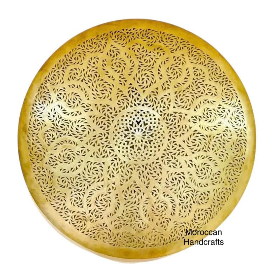 Close-up of a circular Arabesque metal light fixture, showing the detailed cutout design and diffused golden glow.