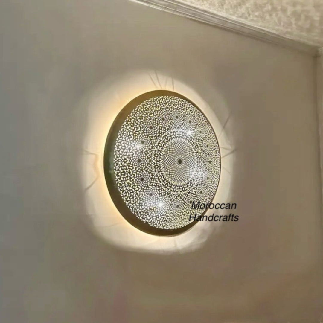 Authentic Moroccan wall lamp illuminated, creating magical shadow patterns in a bohemian style living room at night.