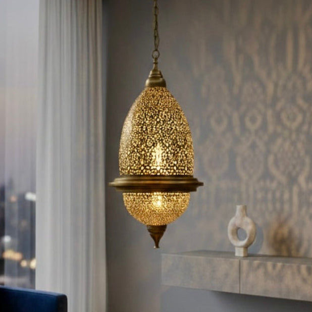 Traditional Moroccan brass lantern in an atmospheric lounge setting, projecting warm geometric shadows.