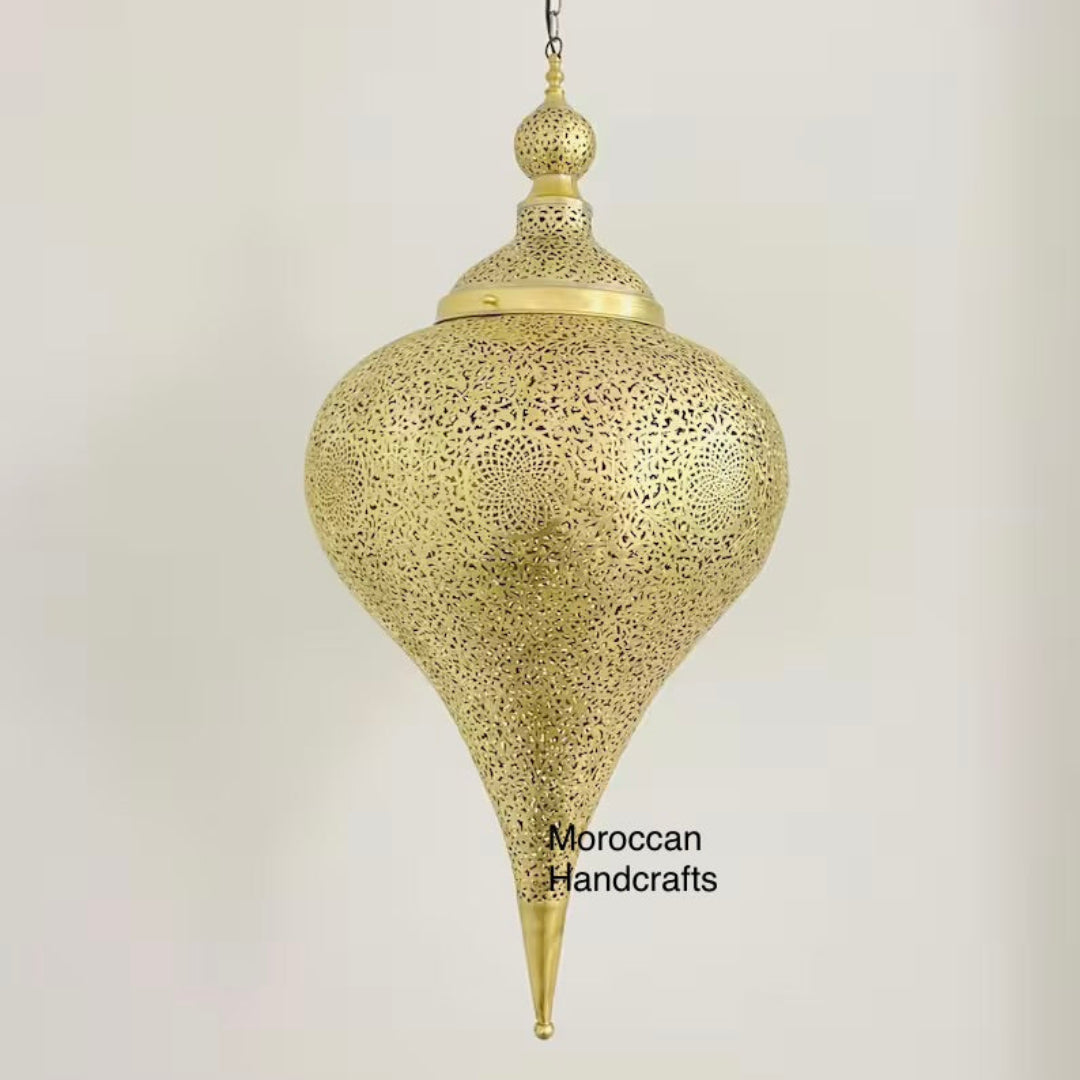 Example of Moorish home decor featuring a striking engraved metal ceiling lamp and classic upholstered armchairs.