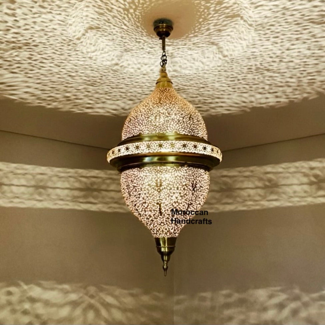 Close-up of hand-punched filigree details on a gold-tone Moroccan brass lantern.

