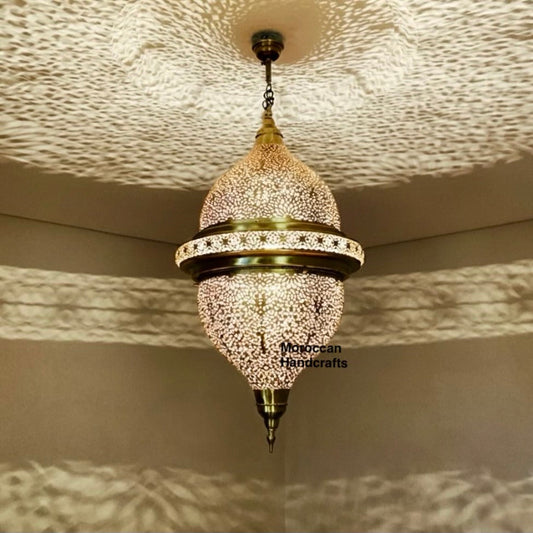 Close-up of hand-punched filigree details on a gold-tone Moroccan brass lantern.

