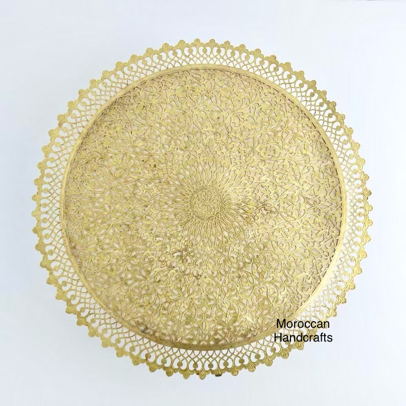 Round Moroccan lamp with detailed brass metalwork creating a beautiful light and shadow effect on the wall. Traditional Moroccan decor.