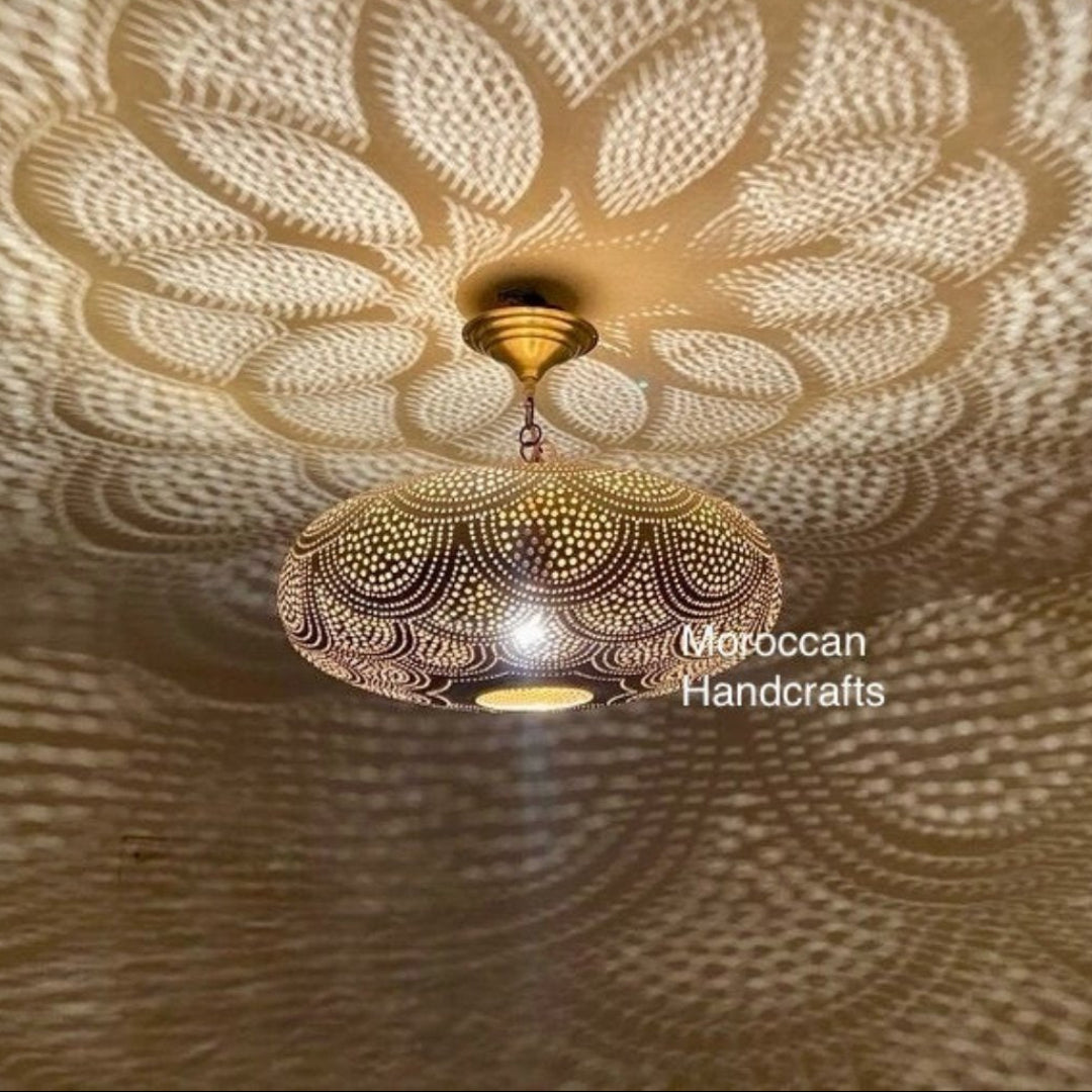 Close-up of a handmade Moroccan brass lamp casting intricate circular shadows on the ceiling