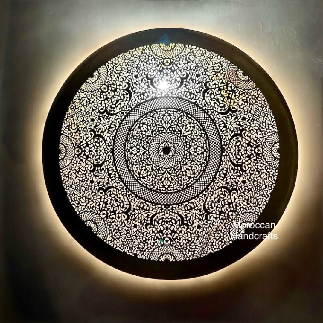Round Moroccan brass wall sconce with dense, intricate floral and geometric filigree design.