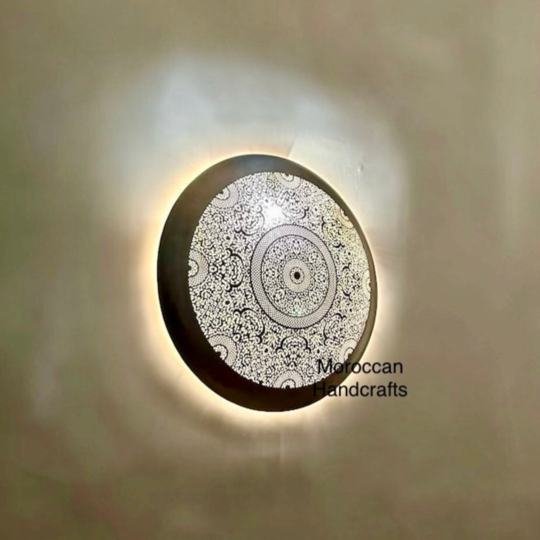 Close-up view of a traditional Moroccan flush mount lamp showing rich, layered brass cut-out artistry.