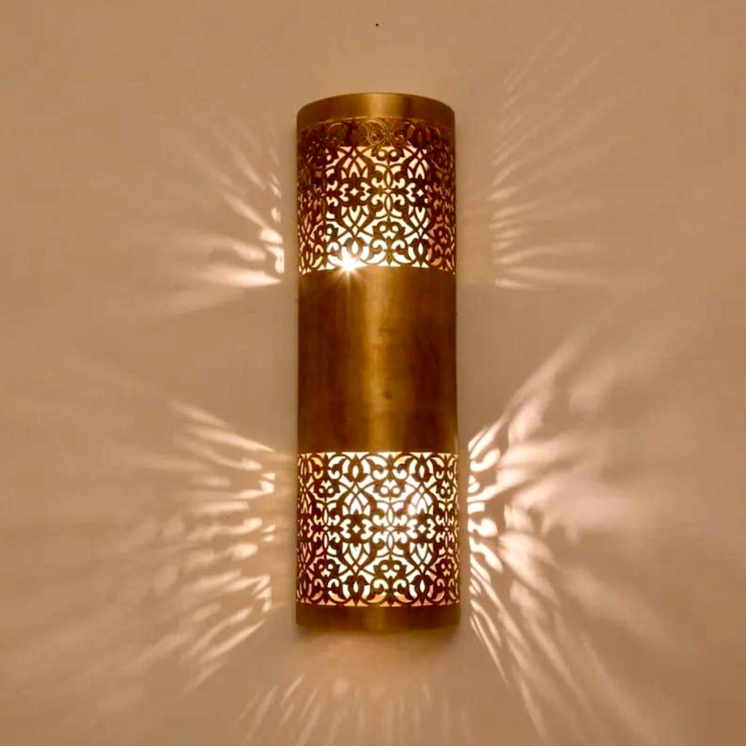 Decorative brass wall light in a Moroccan style creating exotic patterns and a cozy atmosphere in a luxury interior.