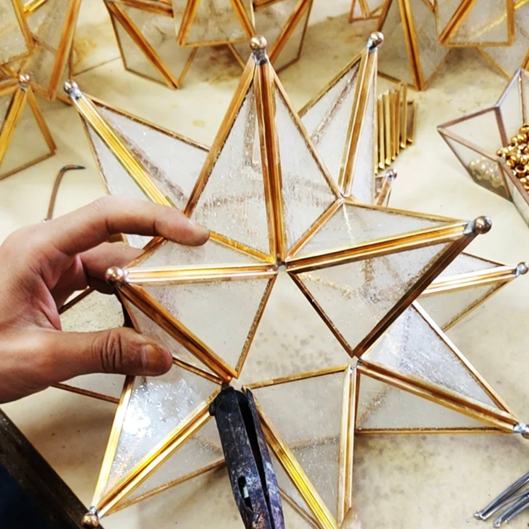  Moroccan star hanging lantern illuminated, casting warm geometric shadows on the wall.