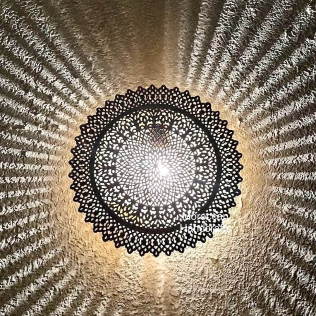 Bright yellow-gold Moroccan brass light fixture with floral-geometric hand-pierced filigree and soft shadow rays.