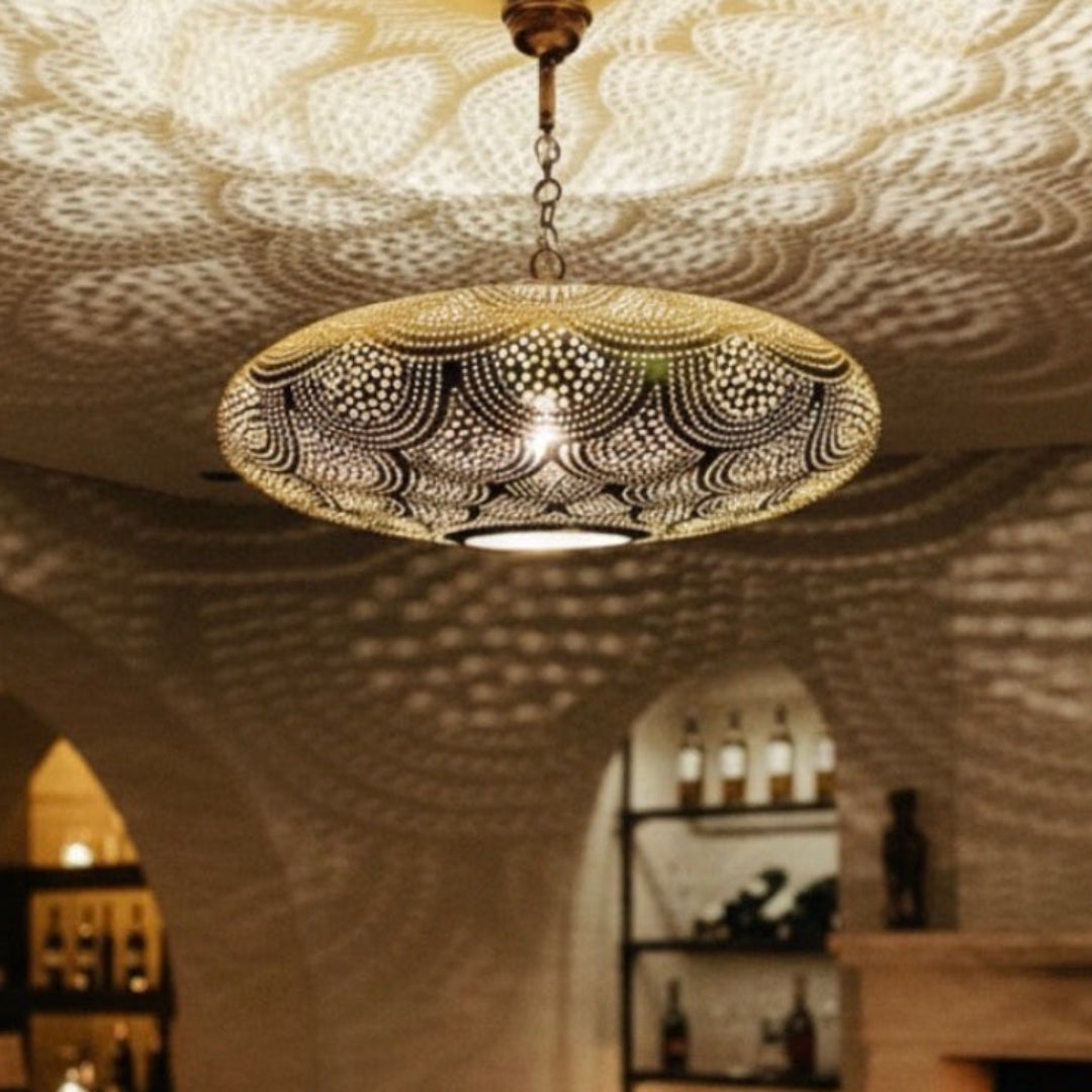 Detailed filigree patterns of an authentic Moroccan brass chandelier in a traditional interior.
