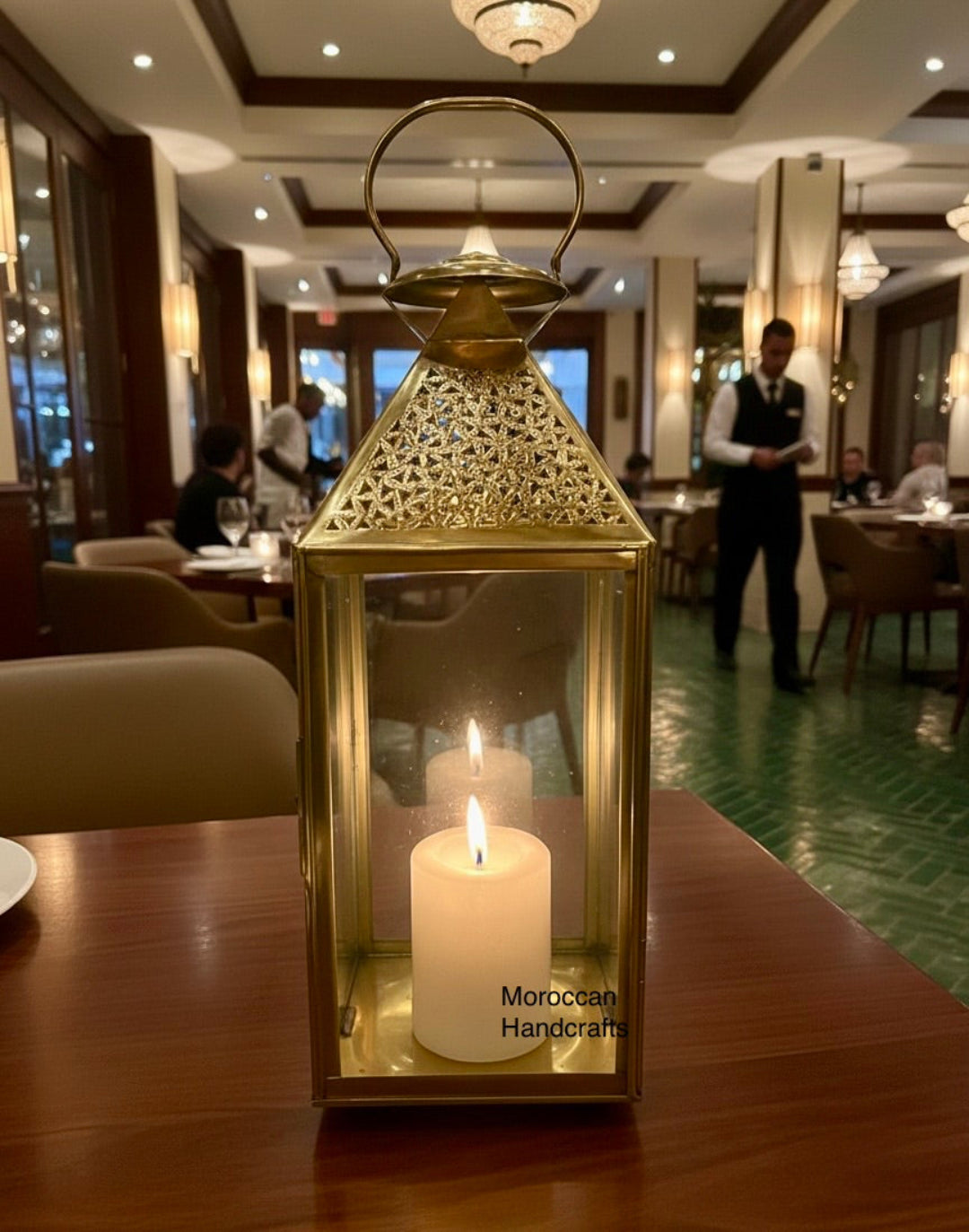  Close-up of a handmade Moroccan brass candle holder showing detailed geometric cutouts and a polished gold metallic finish.