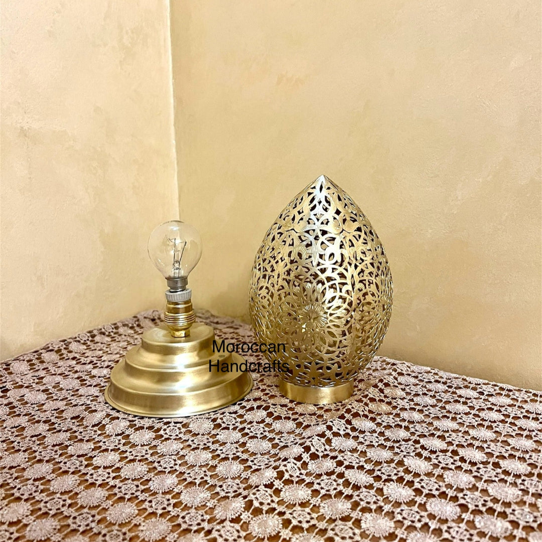 Decorative metal desk lamp with traditional Arabesque pattern cutouts and a warm golden glow.