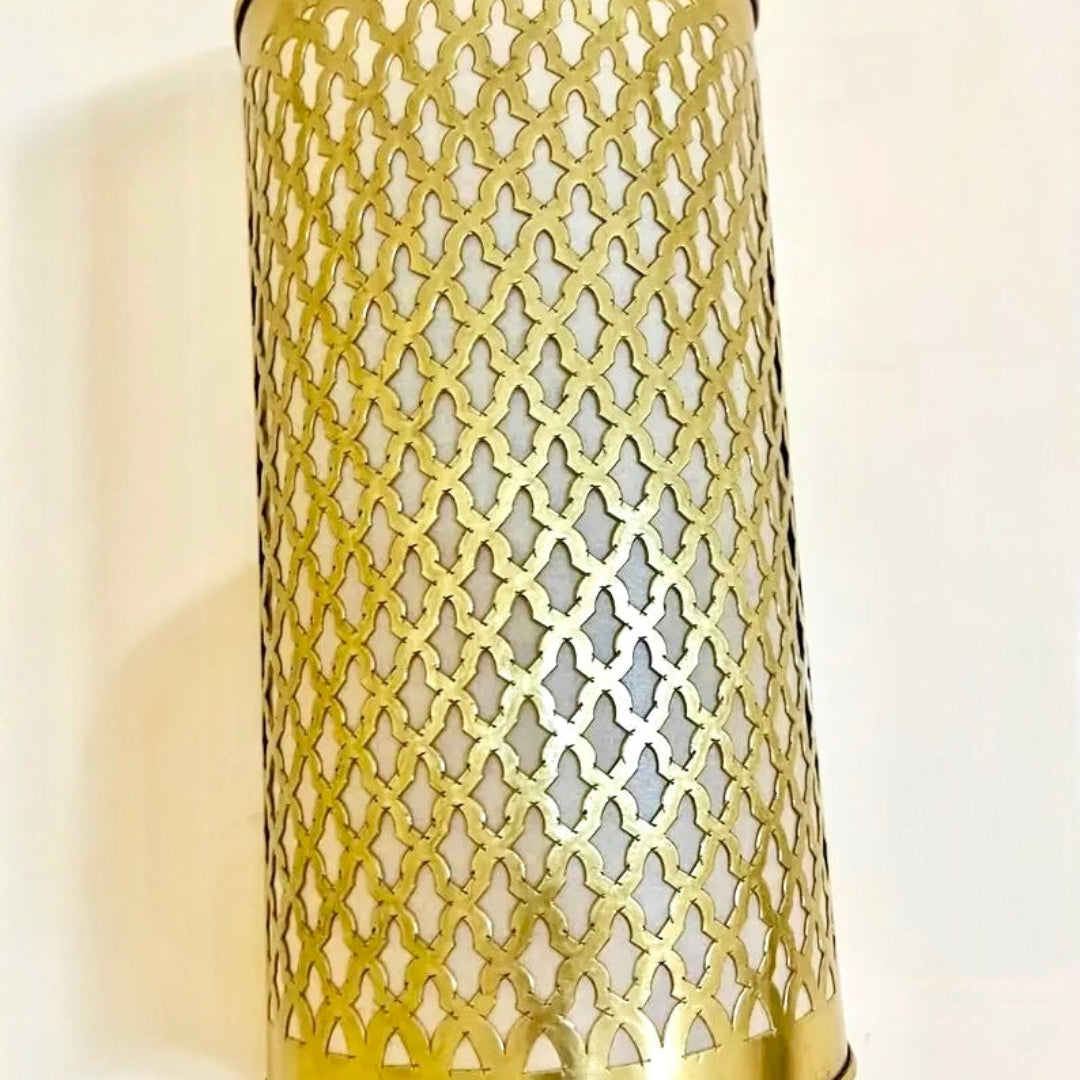 Authentic Moroccan brass wall sconce handcrafted by artisans, showcasing a glow through traditional patterns for a bohemian or industrial chic home.