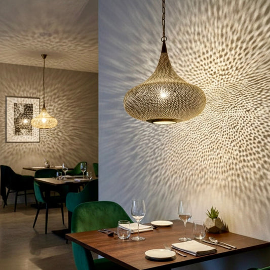  Large authentic Moroccan brass lantern hanging in a traditional Riad courtyard with zellij tilework and plants.