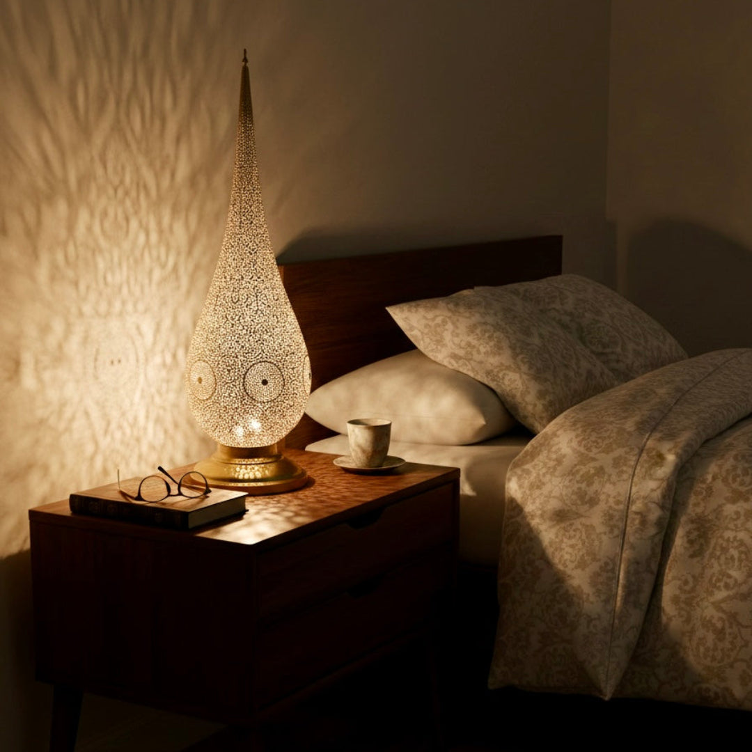 Large Moroccan brass floor lamp placed next to a traditional tiled fireplace, showcasing its height and warm glow.