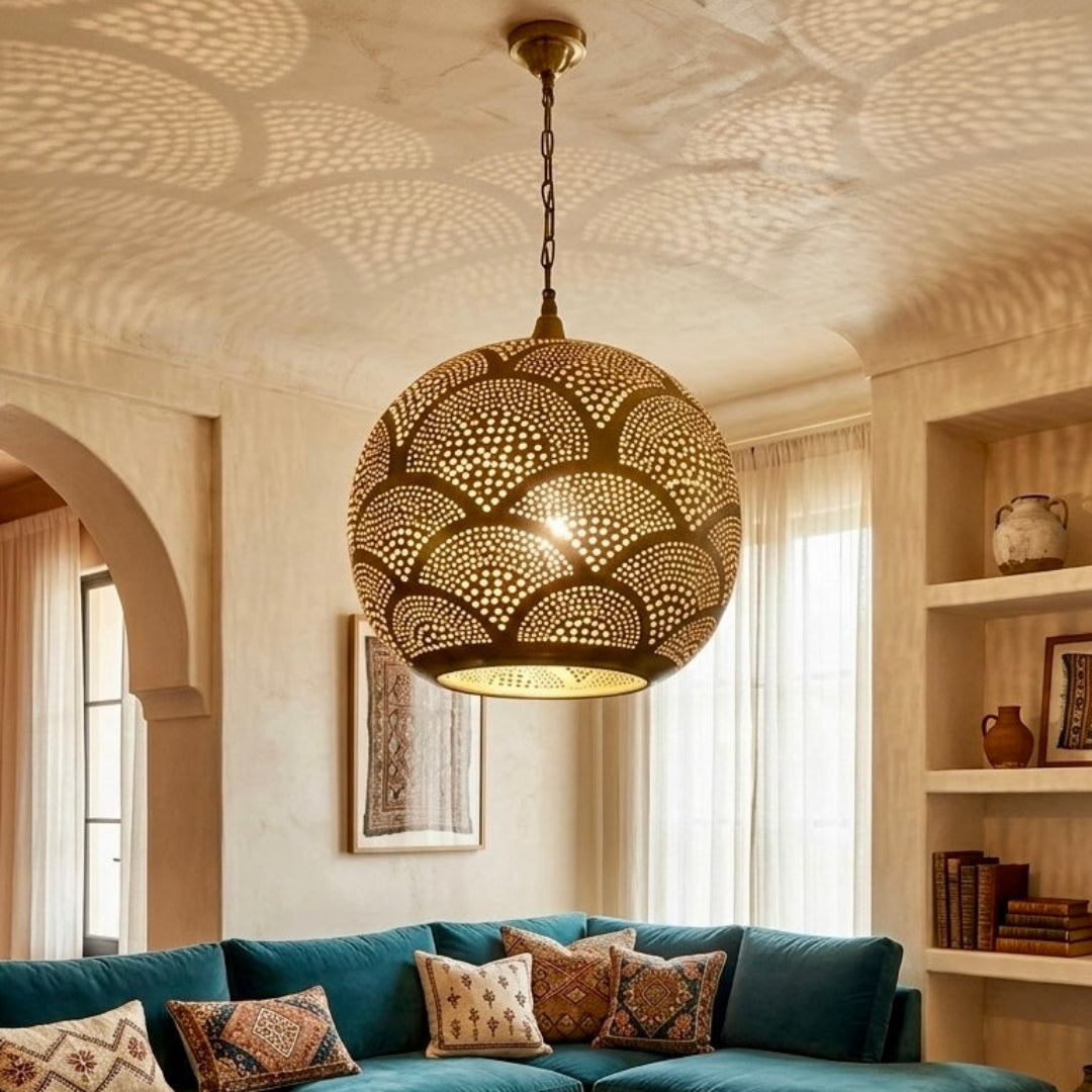 Traditional Moroccan interior with a large teal sectional sofa and arched doorways, featuring a central Moroccan brass lantern that fills the room with artistic shadows