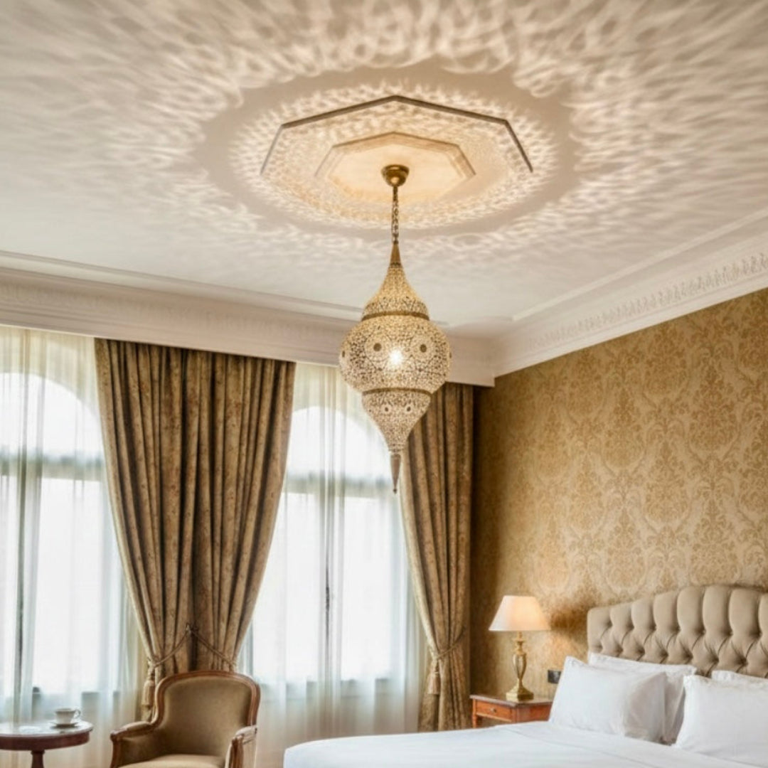 An ornate Moroccan brass lantern hanging in a high-end bathroom with mosaic tiles and a freestanding bathtub.