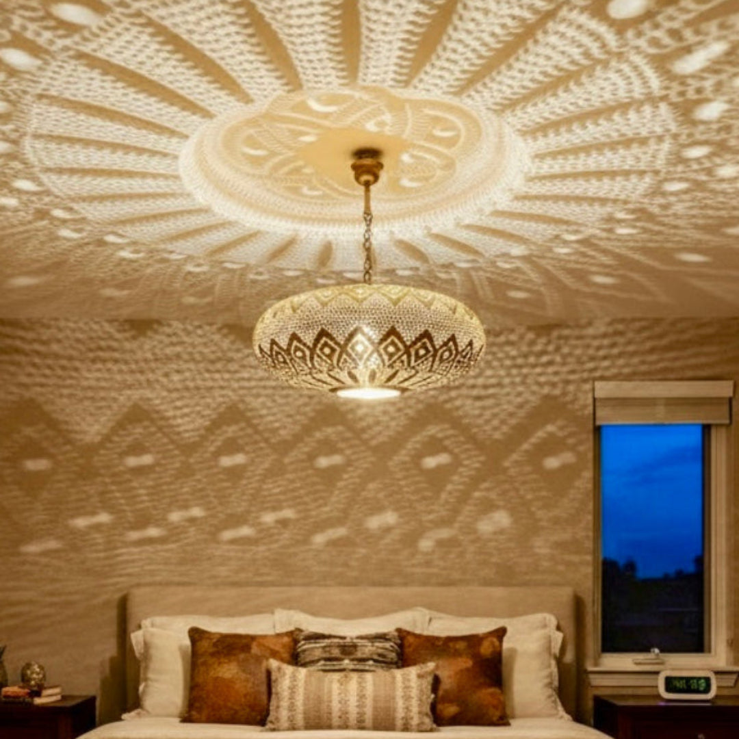 Hand-crafted Moroccan brass lamp creating a warm atmospheric glow in a bedroom.