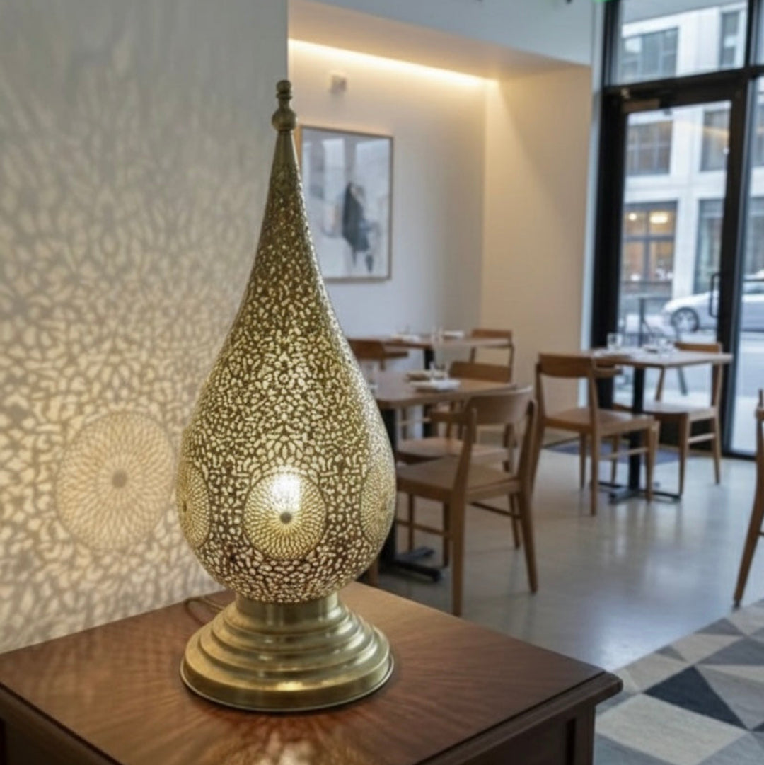 Moroccan brass bedside lamp providing cozy ambient lighting in a minimalist white bedroom.
