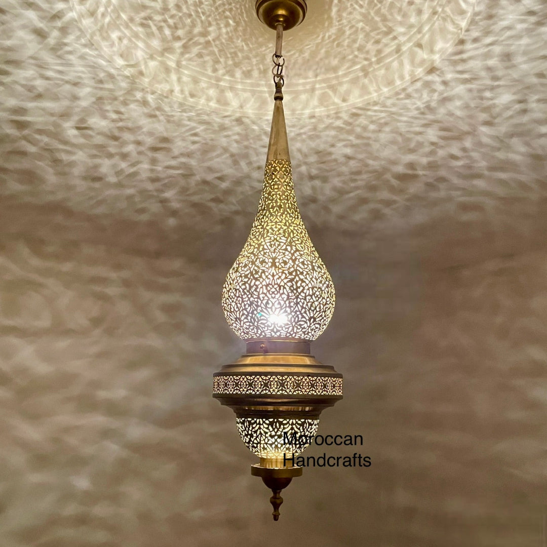  Close-up of a high-quality brass Moroccan lamp, highlighting the dramatic and textured shadow-casting effect on the wall and ceiling.
