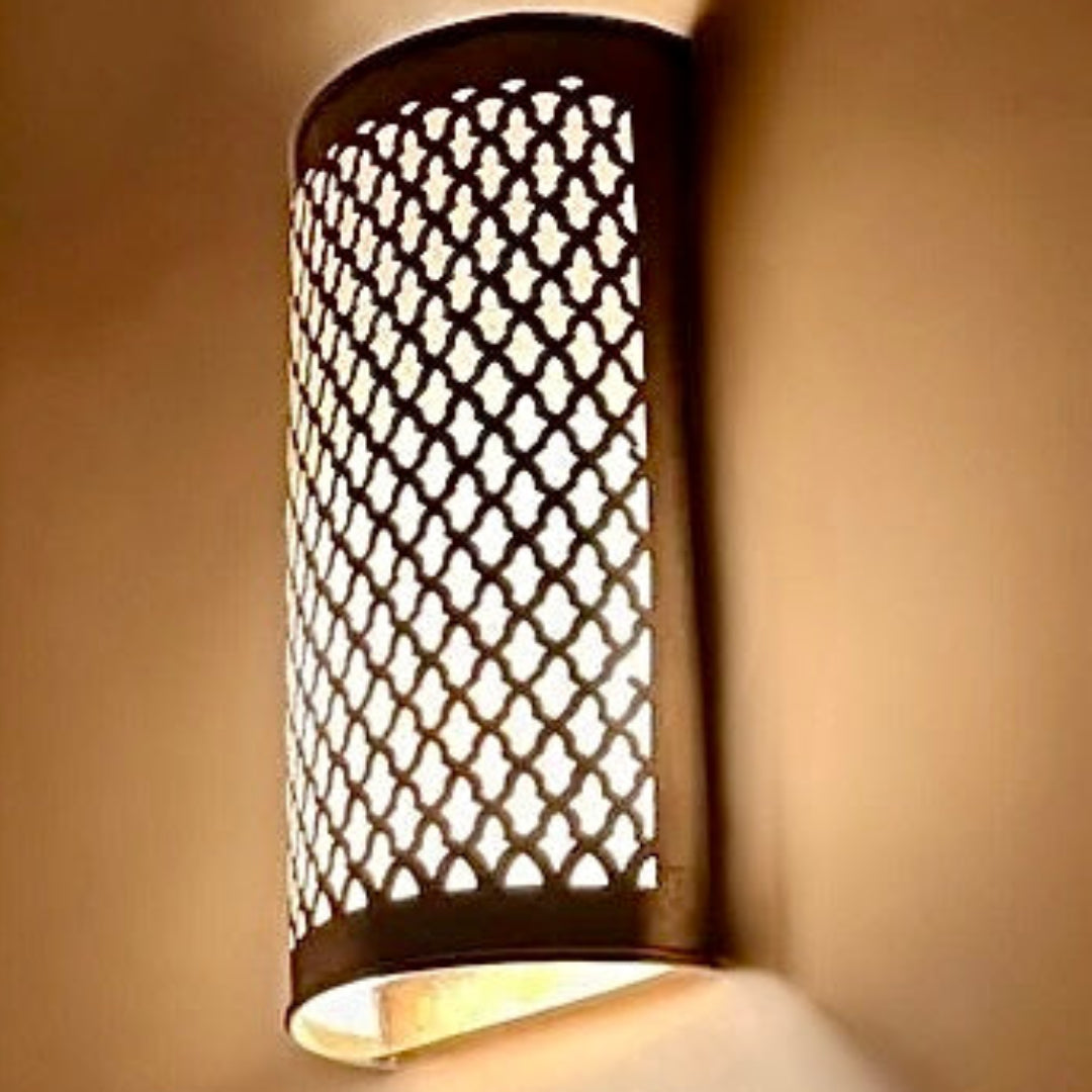 Hand-etched Moroccan brass wall lamp with a traditional cylindrical shape and intricate geometric cutout patterns in a polished gold finish.