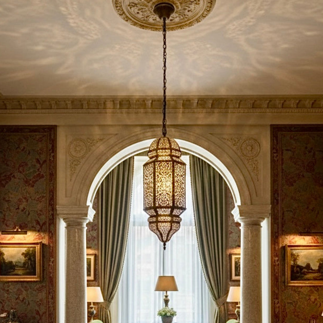 A sophisticated living room interior showcasing a large, hand-hammered brass Moroccan pendant light hanging in a classic, elegant space.