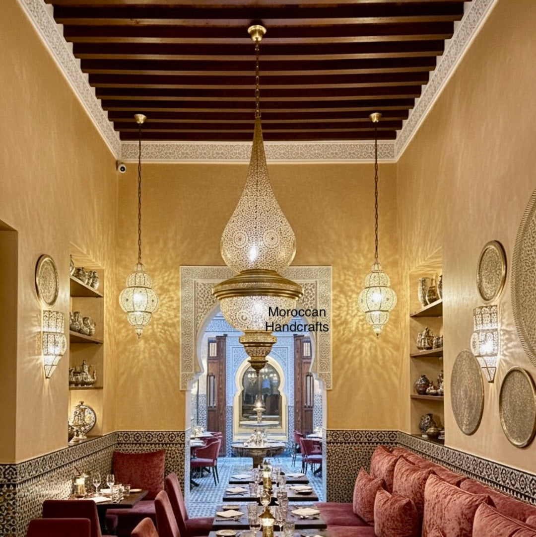 Extra-large, three-tiered Marrakesh style pendant lamp with intricate filigree casting light in a commercial space.