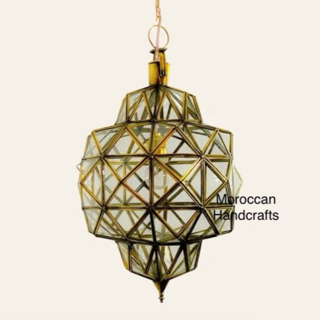 Close-up of a handmade geometric Moroccan ceiling light with antique brass finish and clear glass.