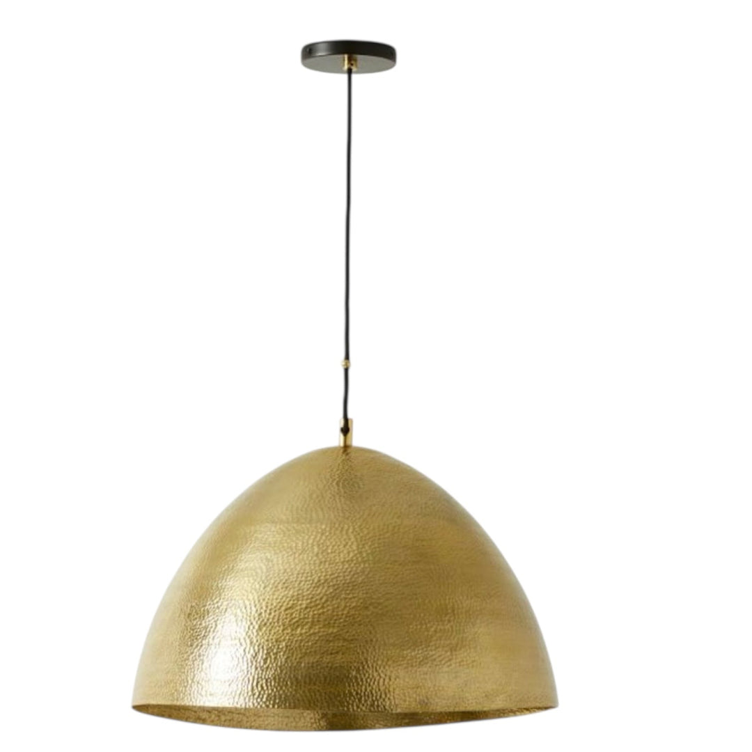 A single handmade hammered brass dome pendant light with a black cord, isolated on a white background.