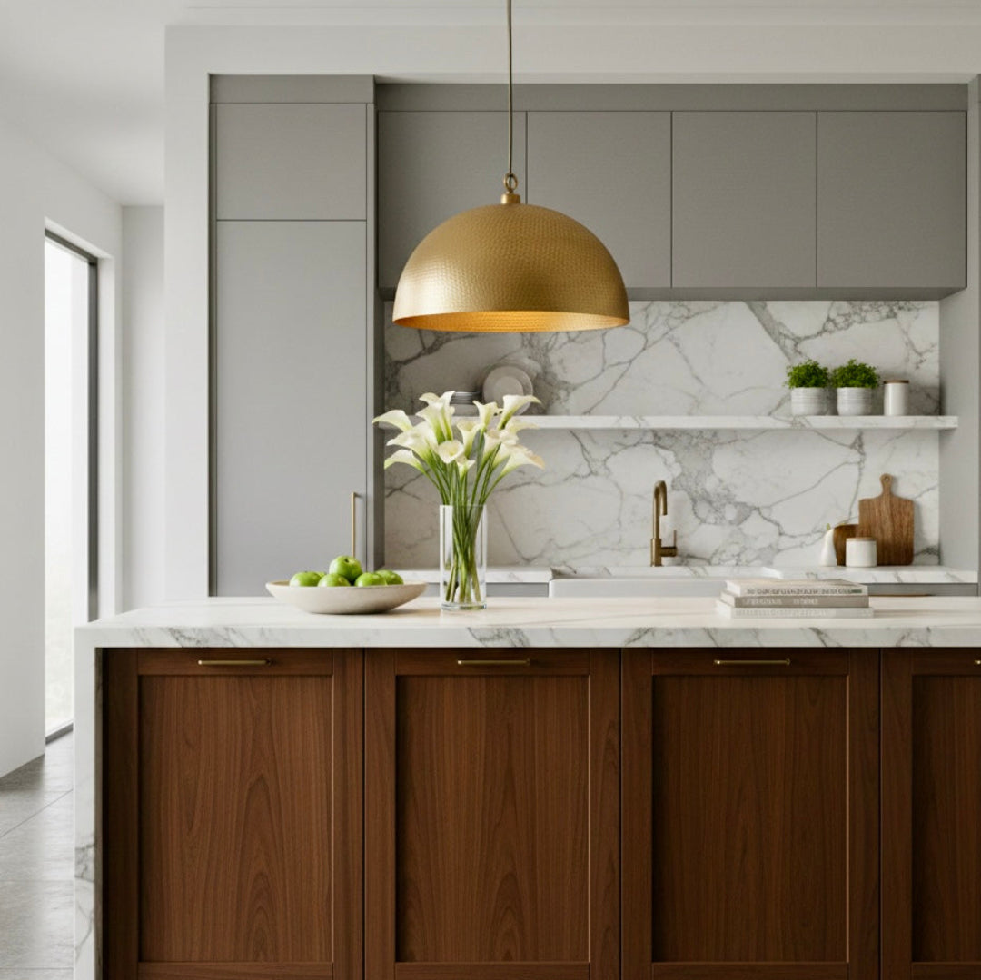  A trio of hammered gold dome pendants over a white marble kitchen island with navy blue velvet bar stools and a city view.