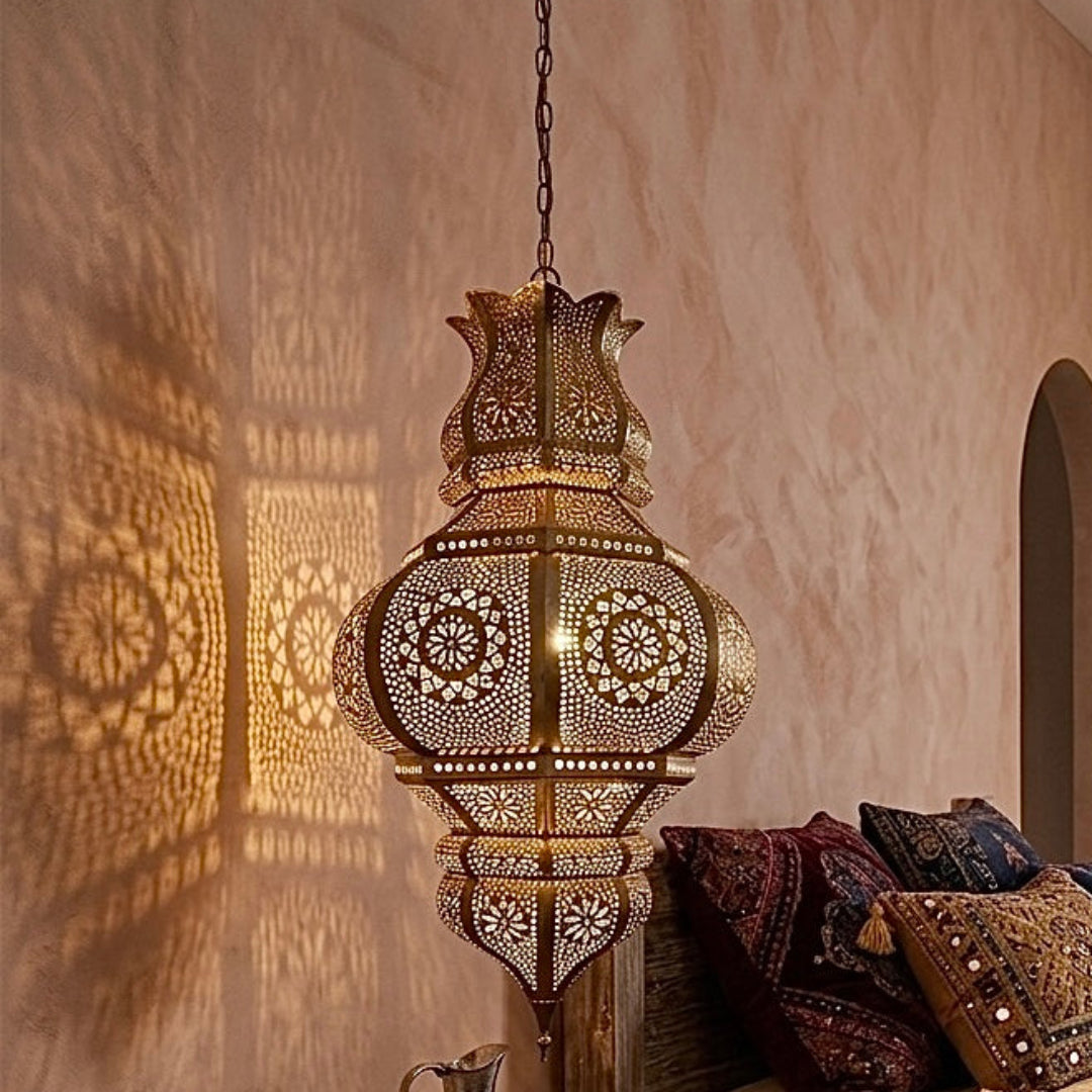  Elegant hand-etched Moroccan brass pendant light hanging in a rustic, bohemian-style bedroom, adding a warm, ambient glow.