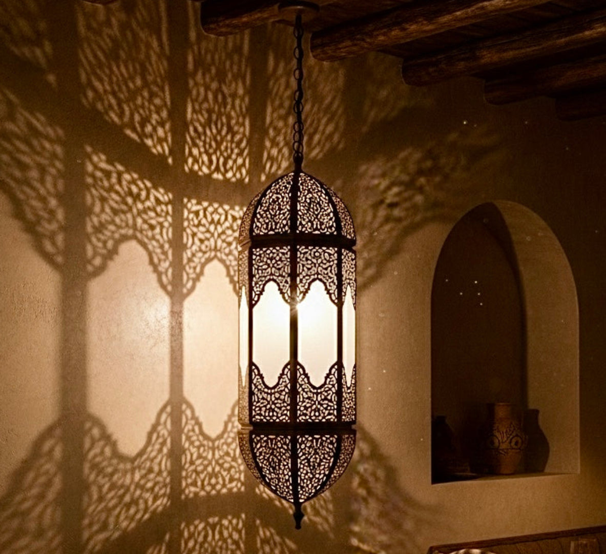 Hand-hammered Moroccan brass lantern casting intricate shadow patterns on a wall in a luxury lounge.