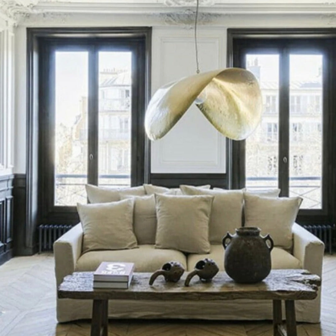Close-up shot of the hand-hammered surface of a solid brass Moroccan lamp showing the authentic golden texture and light reflection.