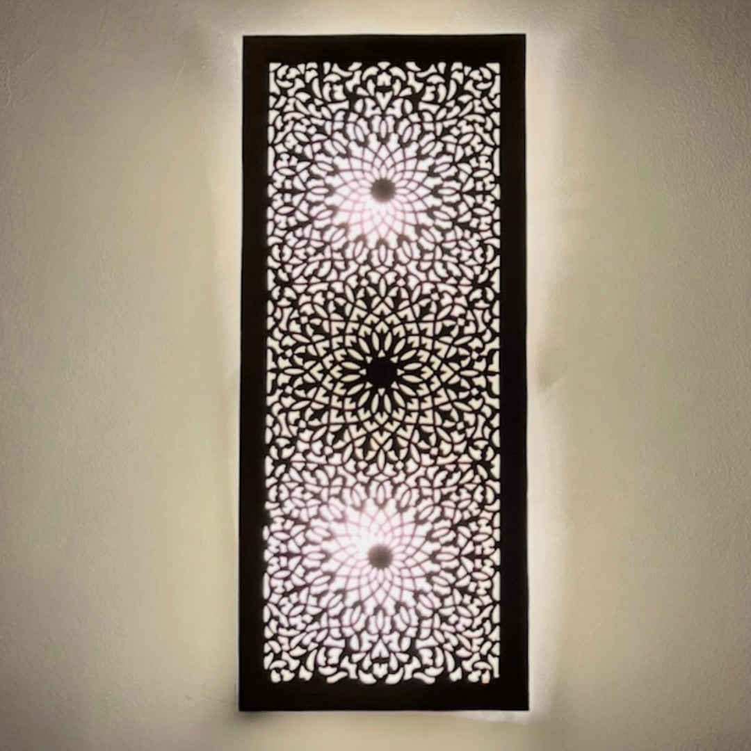 Front view of a rectangular handcrafted Moroccan brass wall lamp featuring intricate geometric filigree patterns on a white wall.