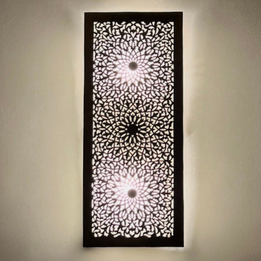 Front view of a rectangular handcrafted Moroccan brass wall lamp featuring intricate geometric filigree patterns on a white wall.