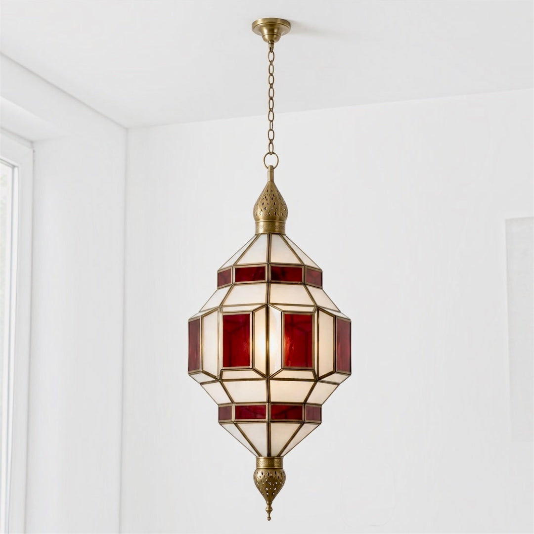  ⁠Close-up view of a glowing Moroccan brass ceiling lamp with red and white glass panels⁠