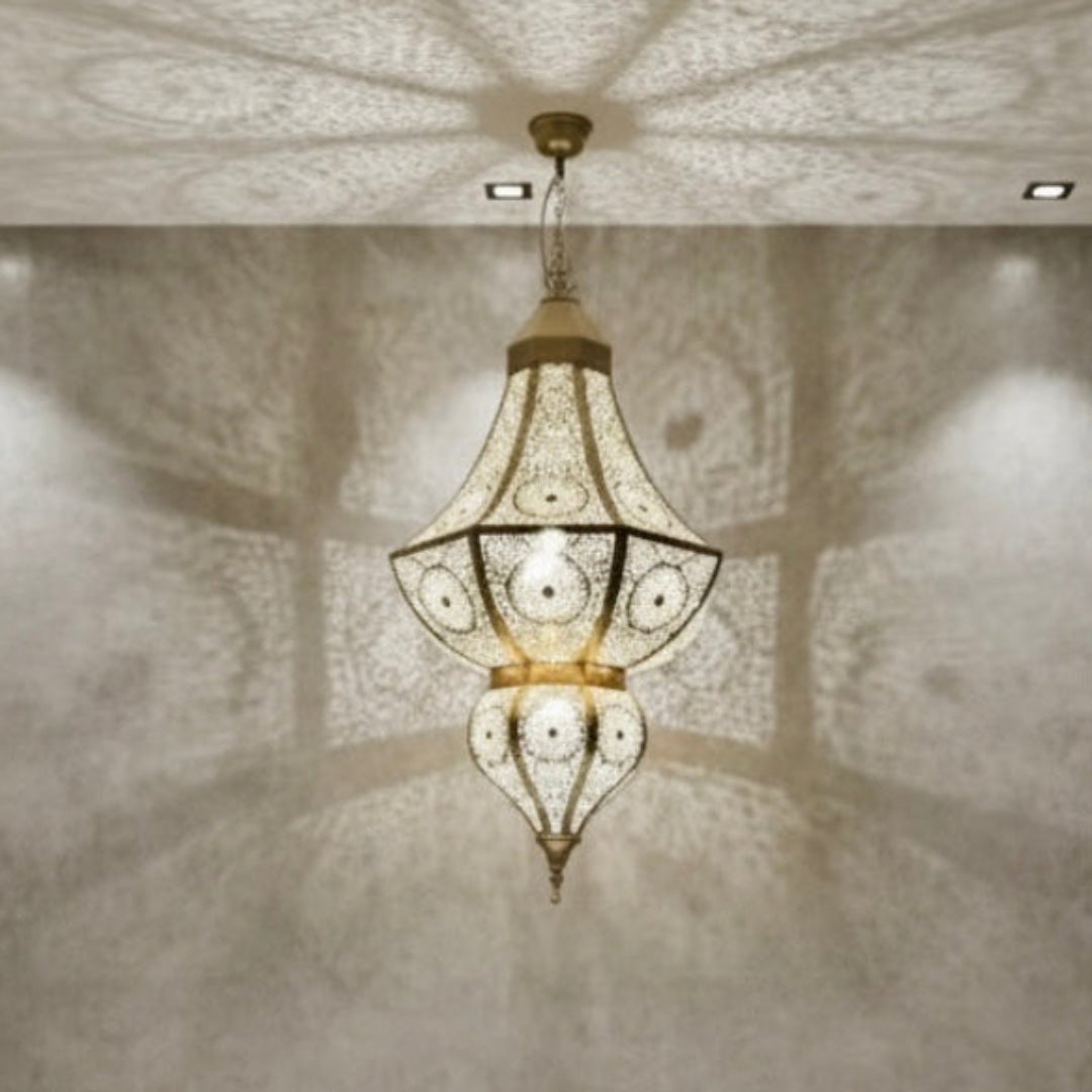 Authentic Moroccan brass lantern in a boho-style bedroom, creating a warm atmosphere with decorative wall shadows.