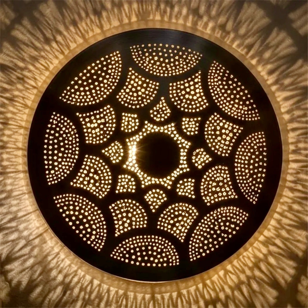  Close-up of a handmade Moroccan flush mount ceiling light showing detailed hand-pierced geometric patterns and the warm ambient shadow projection.