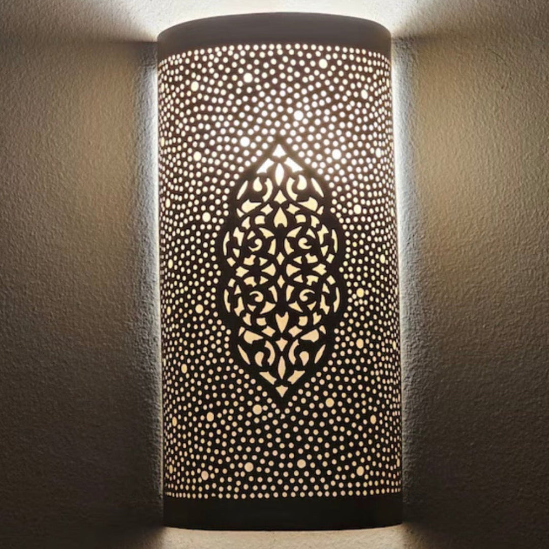 Front view of a handcrafted Moroccan brass wall sconce with intricate geometric perforations on a white background.