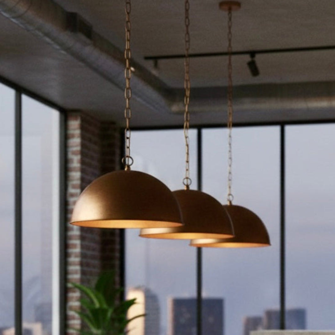 Modern industrial dining space with three copper dome lights, brick walls, and city skyline views.