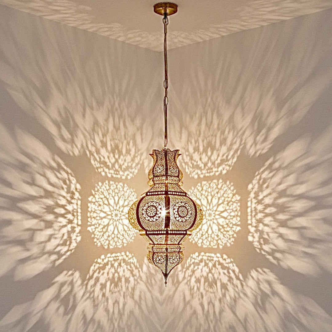 Close-up of a handmade Moroccan brass lantern casting stunning, detailed geometric light patterns on the walls and corner of a room.