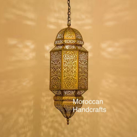  Large handmade Moroccan brass pendant lamp in a modern minimalist restaurant setting, casting intricate light patterns.