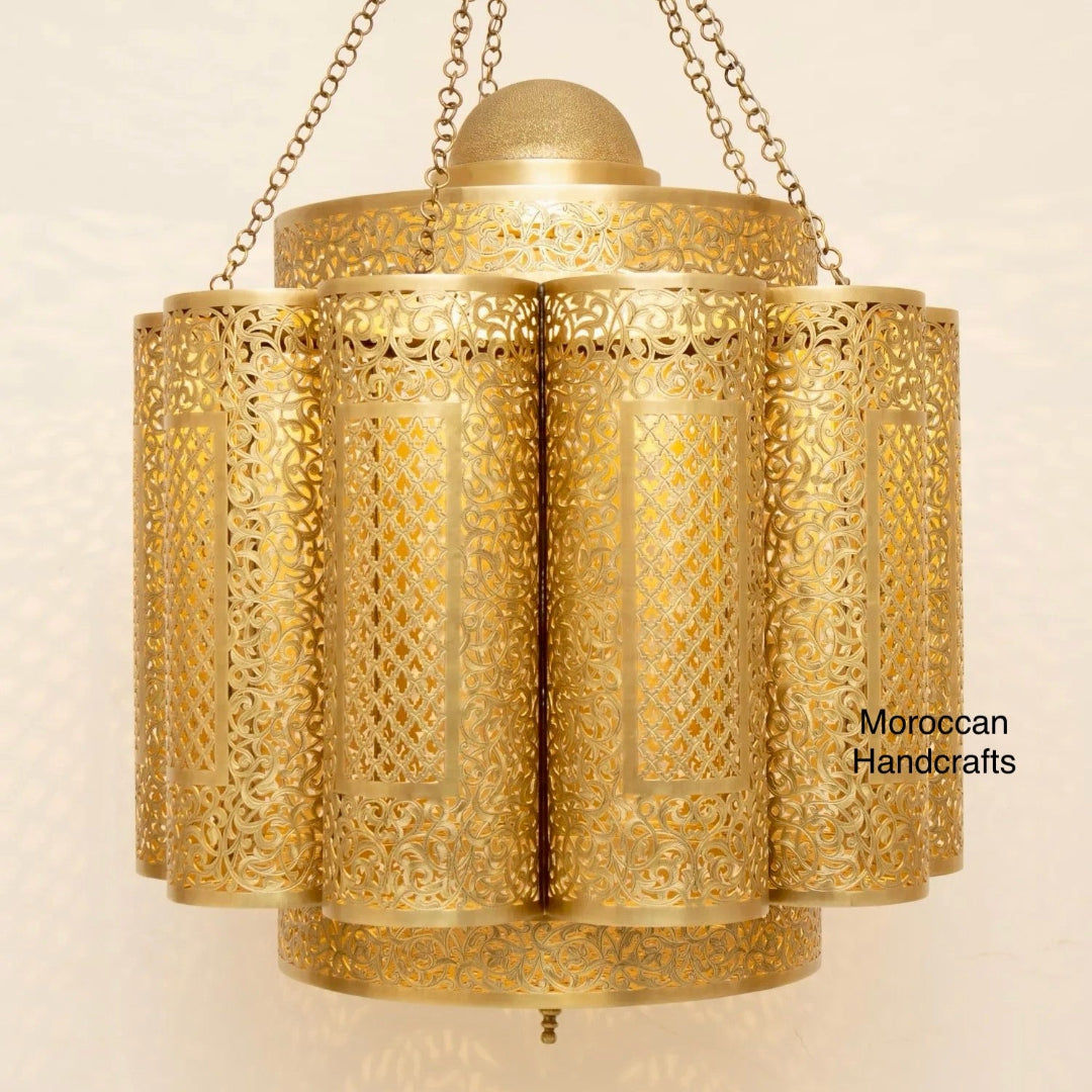  Close-up of a large, traditional Moroccan ceiling lamp showing the detailed perforated brass surface and warm inner light.