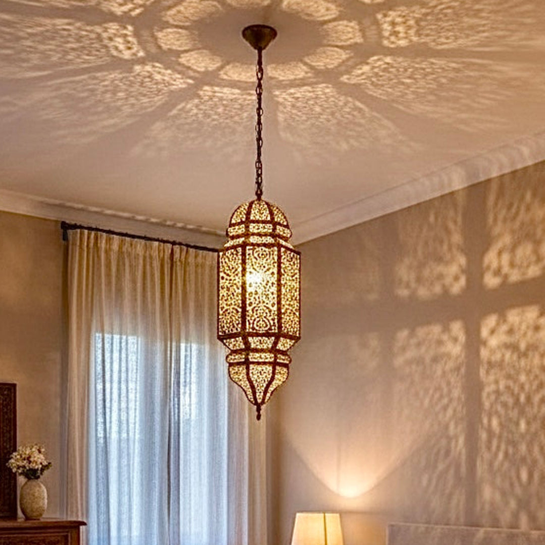  A cozy, luxury bedroom featuring a traditional, handcrafted Moroccan brass lantern, creating warm, intricate lighting patterns on the ceiling.